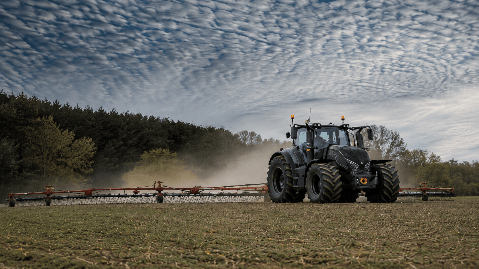 Valtra trekker met hark op het land